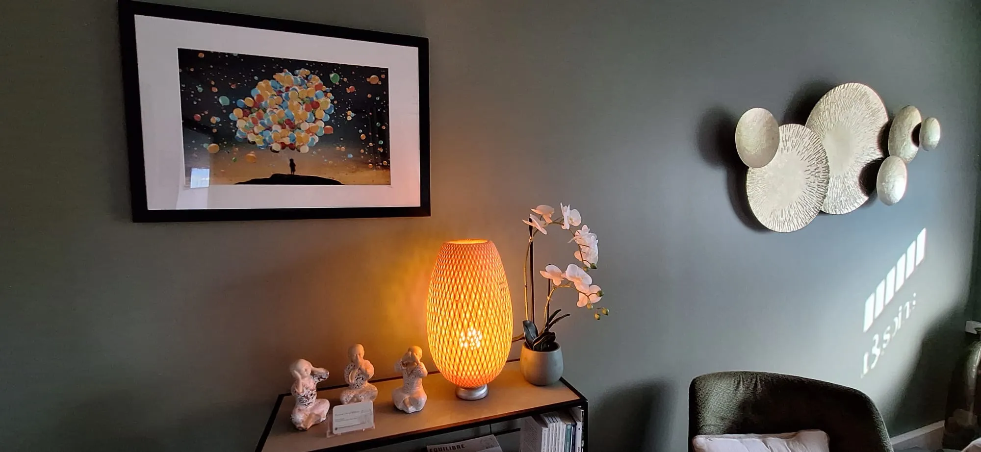 La lampe allumée et l’orchidée, dans l’angle de la pièce.