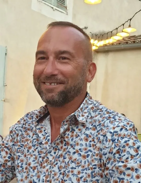 Portrait de Bernard Carret-Ollivier, souriant, en terrasse.