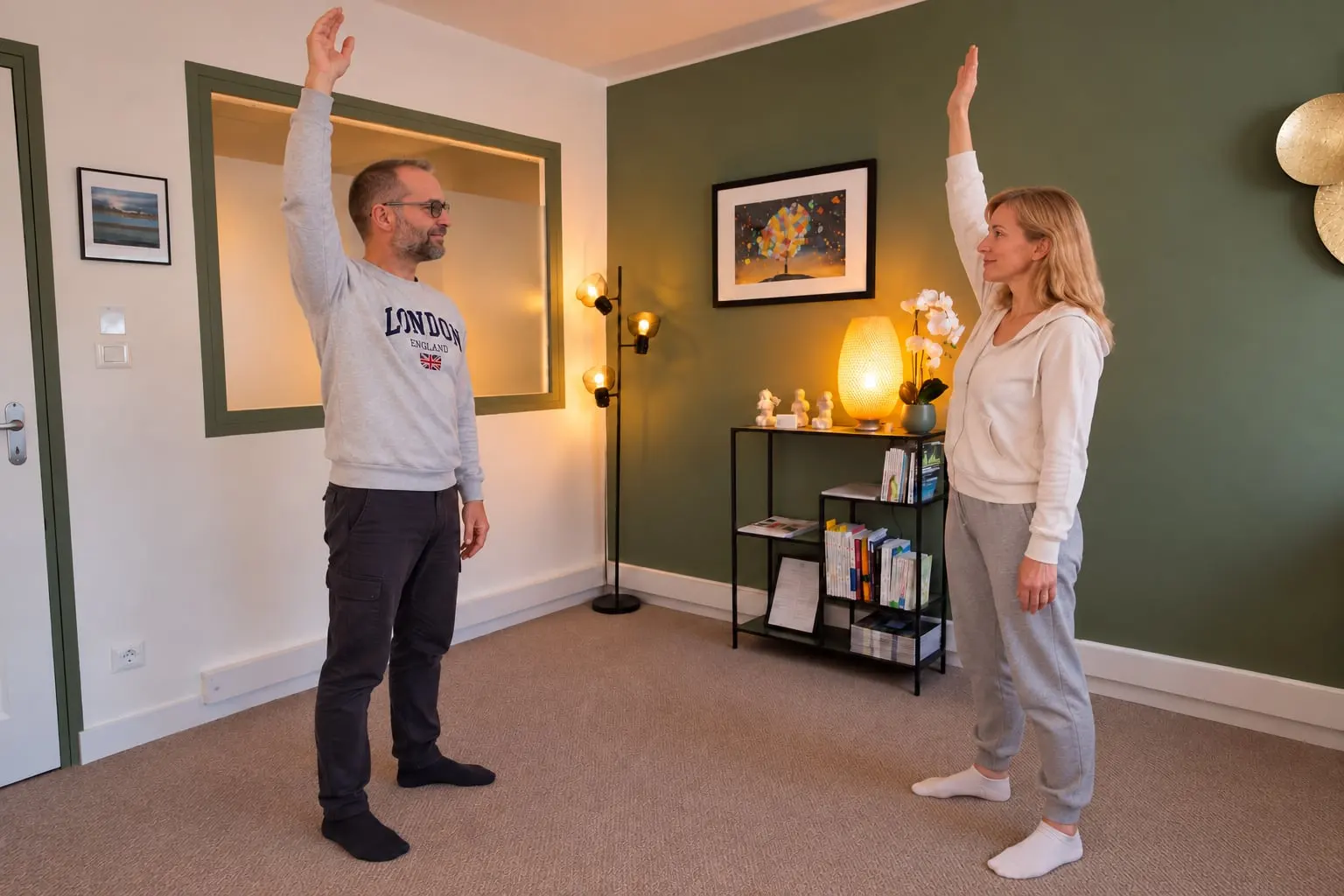 Bernard Carret-Ollivier et une personne accompagnée, debout face à face, les deux bras levés pendant un exercice de relaxation dynamique.